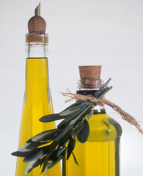 Immagine di una bottiglia di olio con ramo d'ulivo